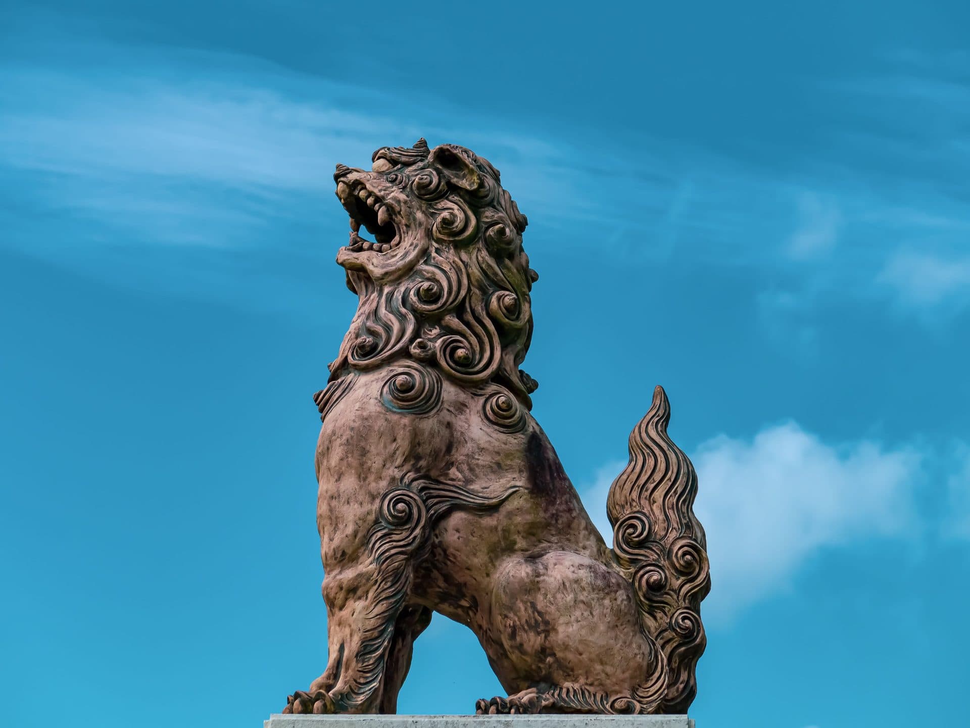 Shisa statue against clear blue sky in okinawa