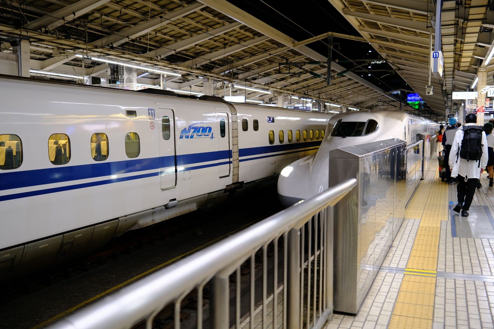 Shinkansen-Hochgeschwindigkeitszug am belebten Bahnsteig eines Tokioter Bahnhofs, Reisende beim Einsteigen