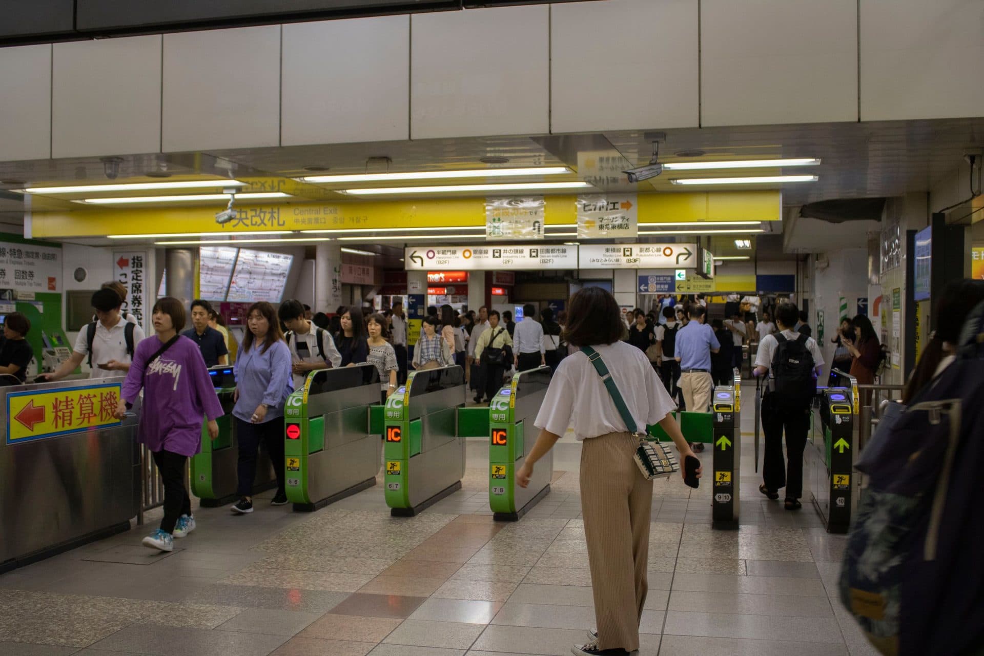 Crowded entrance of a Tokyo subway station with commuters passing through ticket gates