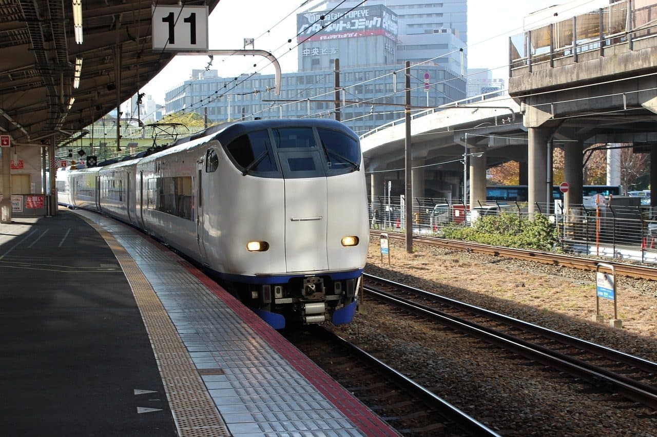 A white and blue Haruka limited express train, which runs between Kansai Airport and Kyoto, standing at a JR West platform